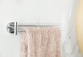 Holder with clean towel on wall in bathroom