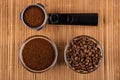 Holder from coffee maker with coffee, bowl with fried coffee beans, bowl with ground coffee on mat. Top view Royalty Free Stock Photo