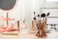 Holder with different makeup brushes on dressing table Royalty Free Stock Photo