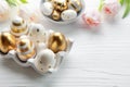 Holder with Easter eggs painted golden colors on a white wooden background Royalty Free Stock Photo