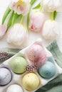 Holder with Easter eggs painted pastel colors on a white wooden background Royalty Free Stock Photo