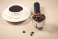 holder filled with beans and coffee cup/holder filled with beans and coffee cup on a stone background, selective focus Royalty Free Stock Photo