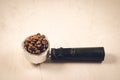 Holder filled with coffee beans/Filter holder filled with coffee beans on a concrete background. Copyspace