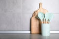 Holder with kitchen utensils and cutting boards on grey table. Space for text Royalty Free Stock Photo