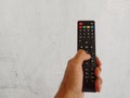 holding a black remote to control