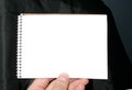 Holding blank spiral notebook on abstract background