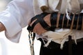 Holding blue techelet tzitzit during Jewish prayer