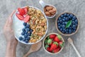 Holding bolw of homemade granola yogurt with fresh berries Royalty Free Stock Photo