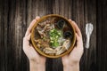 holding bowl Homemade noodle Vietnam food, Traditional Vietnamese soup and rice pudding on a wooden background, pork noodle rice Royalty Free Stock Photo
