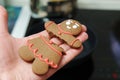 Hands holding a homemade broken gingerbread man. Close up