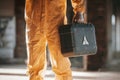 Holding case and flashlight. Man dressed in chemical protection suit in the ruins of the post apocalyptic building Royalty Free Stock Photo