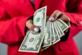 holding cash fans of dollars in hands in white shirt and red jacket isolated on solid color Royalty Free Stock Photo