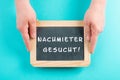 Holding a chalkboard in the hands, looking for a new tenant is standing in german language on the sign, moving to a new home Royalty Free Stock Photo