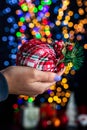 Holding Christmas bauble decoration isolated on background with blurred lights. December season, Christmas composition Royalty Free Stock Photo