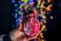 Holding Christmas bauble decoration isolated on background with blurred lights. December season, Christmas composition Royalty Free Stock Photo