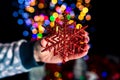 Holding Christmas snowflake decoration isolated on background with blurred lights. December season, Christmas composition Royalty Free Stock Photo