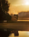 Holding a coffe mug in a warm auttum sunset Royalty Free Stock Photo