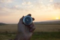 Holding a compass on the background of fields at sunset Royalty Free Stock Photo