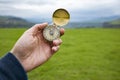 Holding a compass on the background of a green field Royalty Free Stock Photo