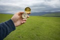 Holding a compass on the background of a green field Royalty Free Stock Photo