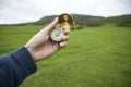 Holding a compass on the background of a green field Royalty Free Stock Photo