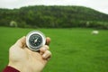 Holding a compass on the background of a green field Royalty Free Stock Photo