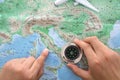 Holding a compass in hand to look up a certain location on the map of Europe Royalty Free Stock Photo