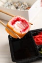 Holding delicious sushi roll with chopsticks over soy sauce on table, closeup Royalty Free Stock Photo