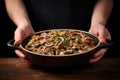 holding a dish of freshly cooked beef stroganoff