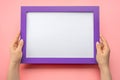 Holding frame mockup. Photo Mockup. Woman hands hold purple frame on pink wall background. Frame size A4. blank photo frame border Royalty Free Stock Photo