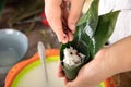 Holding a freshly wrapped zongzi in hand