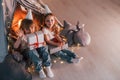 Holding gift boxes. Conception of presents and holidays. Two little girls is in the tent in domestic room together Royalty Free Stock Photo