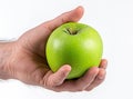 Holding a green apple on a white background, a close up view of a male hand with a fresh organi Royalty Free Stock Photo
