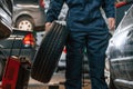 Holding it in hand. Close up view of man that is moving tire of the car Royalty Free Stock Photo
