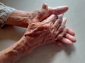 Holding hands, Asian old woman, she is 70 years, with wrinkles that has a surface on smooth sheet in the background Royalty Free Stock Photo