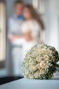 Holding hands of groom and bride and wedding bouquet in the middle.Wedding bridal bouquet made of white roses. Royalty Free Stock Photo