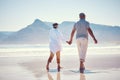 Holding hands, love and an old couple walking on the beach in summer with blue sky mockup from behind. Care, romance or Royalty Free Stock Photo