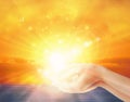 Hands with spark of hope, holding the sun, the light of faith, spiritual freedom, yellow sunetbackground