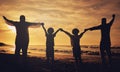 Holding hands, sunset and silhouette of a family at the beach with love, freedom and happiness. Summer, travel and back