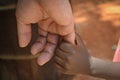 Holding hands of white man and black kid in Africa