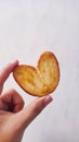 holding a heart-shaped pie biscuit on a gray background Royalty Free Stock Photo