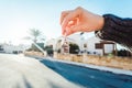 Holding house keys on house shaped keychain closeup in front of a new home Royalty Free Stock Photo