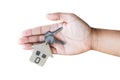 Holding house keys on house shaped keychain in front of a new ho Royalty Free Stock Photo