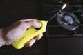 Holding and Lightening a Kitchen Gas Lighter Over a Stove