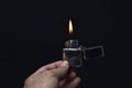 Holding lighter lit on black background Royalty Free Stock Photo