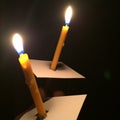Holding 2 lighting candle in the dark