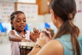 Holding and manipulating instruments is excellent fine motor skills practice. a woman teaching a child about musical Royalty Free Stock Photo