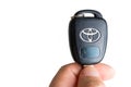 Holding onto a car Toyota car key and showing off the Toyota logo. Close up Royalty Free Stock Photo