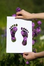 Holding papercut miniature toe heels over blooming flowers