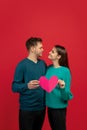 Beautiful couple in love on red studio background. Valentine's Day, love and emotions concept Royalty Free Stock Photo